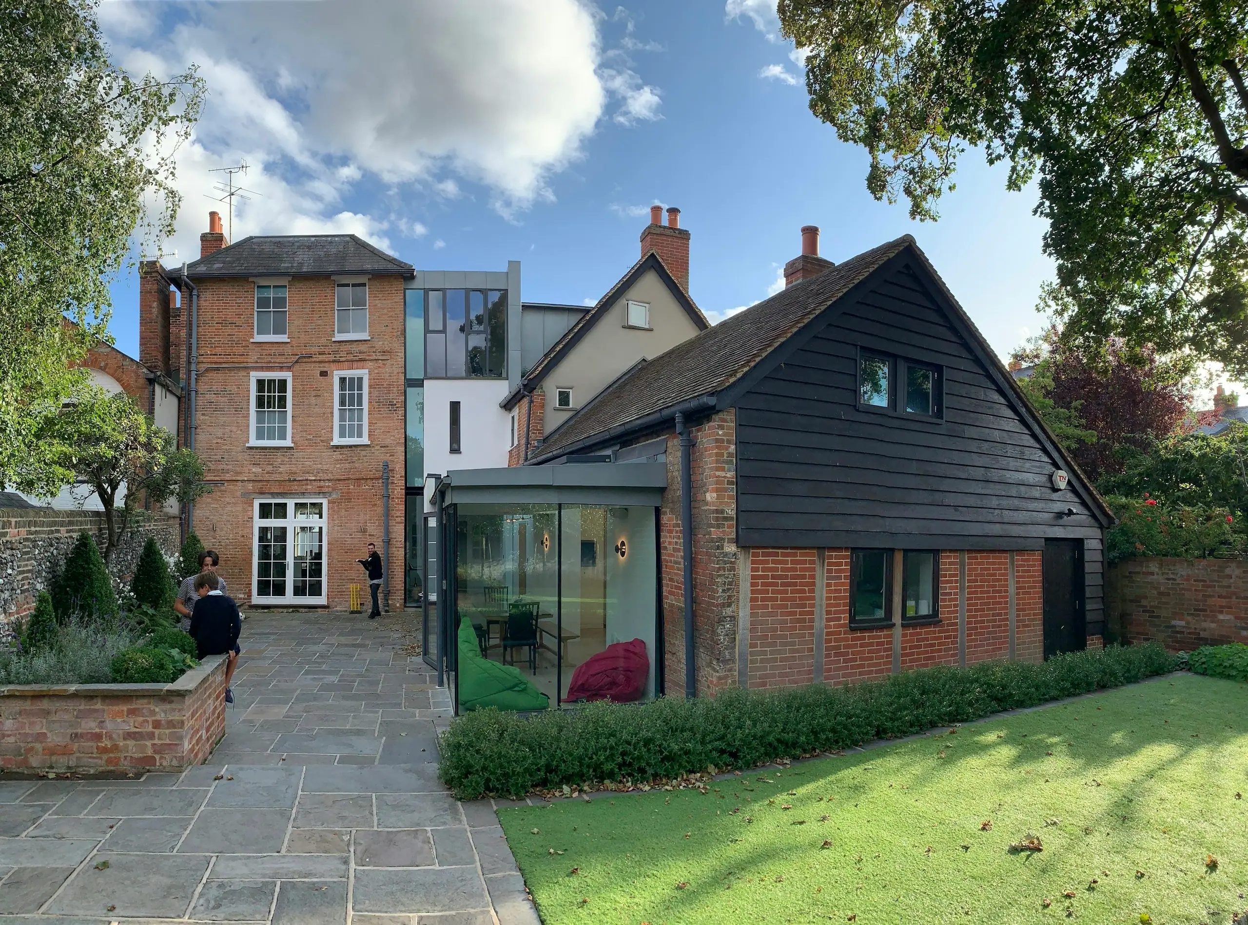 Brick UK home with a modern black-clad extension and landscaped garden